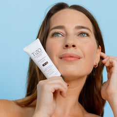 Aplicación del TIZO AM Replenish SPF 40 sobre rostro
